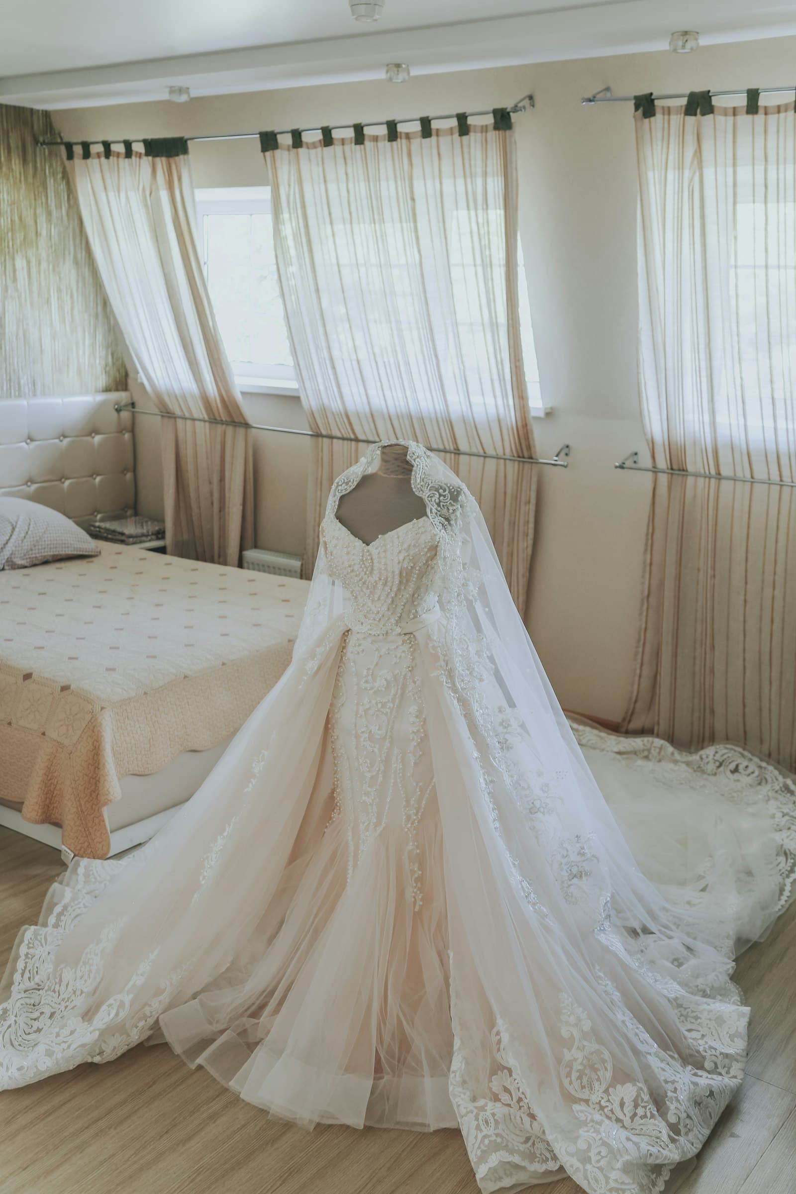 Bride and groom lying on a veil spread across the grass